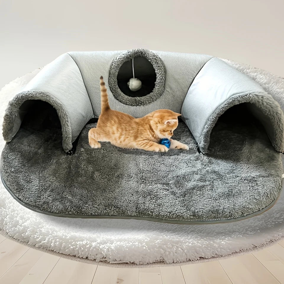 Cat playing in cozy tunnel bed with hanging toy ball
