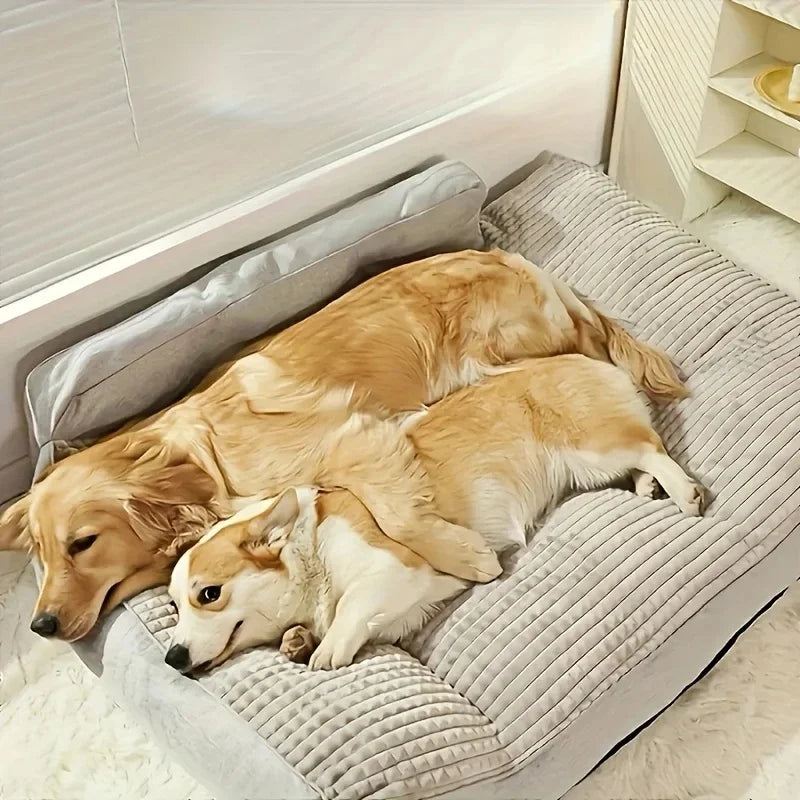 Golden retriever and corgi cuddling on large grey dog bed