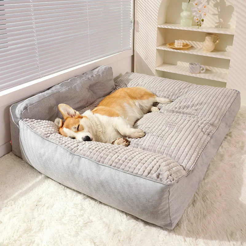 Corgi sleeping on large grey orthopedic dog bed in living room
